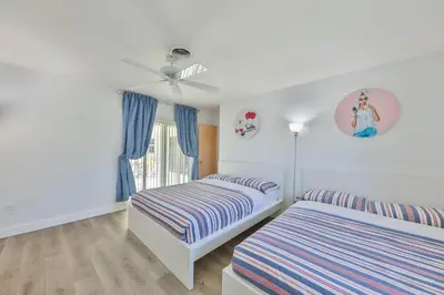 a bedroom with two beds and a ceiling fan at Family Grand Advantage in Hollywood