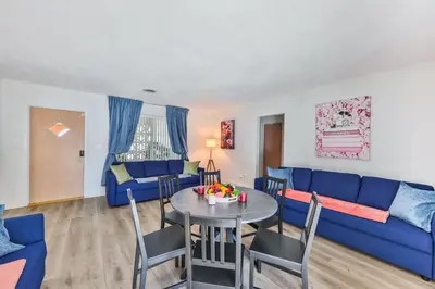 a living room with a blue couch and a table at Family Grand Advantage in Hollywood