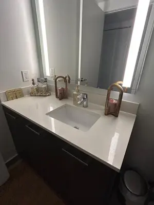 a bathroom counter with a sink and a mirror at Miami-Brickell Skyline Luxury High Rise 2BR-2BATH - walking distance to KASEYA - HEAT ARENA - BAYSIDE - PORT OF MIAMI CRUISE SHIPS in Miami