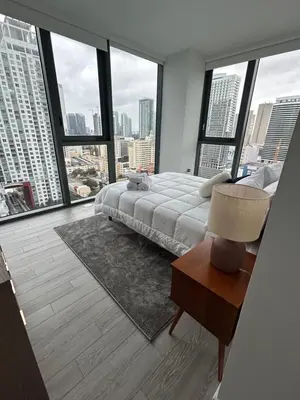 a bedroom with a bed and large windows at Miami-Brickell Skyline Luxury High Rise 2BR-2BATH - walking distance to KASEYA - HEAT ARENA - BAYSIDE - PORT OF MIAMI CRUISE SHIPS in Miami
