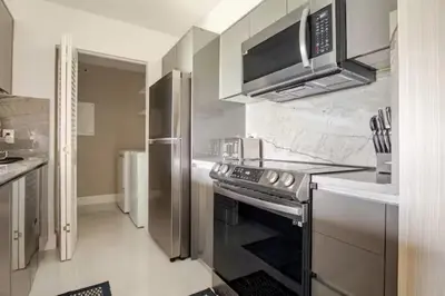 a kitchen with a stove and a microwave at The Yacht Club at Aventura Miami 9505 in South Island