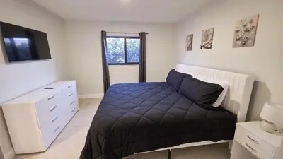 a bedroom with a bed and a dresser and a television at Apartment close to shops & beach-Free Parking 109 in Hollywood