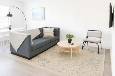 a living room with a couch and a table and a chair at Modern 2BR Stay with Desk, Patio, BBQ, Free Parking in Fort Lauderdale