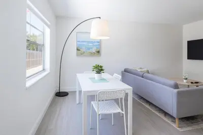 a living room with a table and a couch at Modern 2BR Stay with Desk, Patio, BBQ, Free Parking in Fort Lauderdale