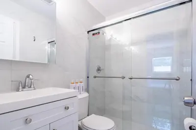 a bathroom with a shower and a toilet and a sink at Modern 2BR Stay with Desk, Patio, BBQ, Free Parking in Fort Lauderdale