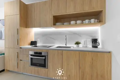 a kitchen with a sink and a stove and cabinets at Stylish City Retreat With Private Balcony in Miami