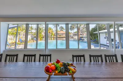 a bowl of fruit on a table in a room with a pool at 50 Shades of Grey on the Canal Villa STR-4500 in Fort Lauderdale