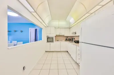 a large kitchen with white cabinets and a ceiling at Coastal Elegance Oasis in Sunny Isles STR-01308 in Sunny Isles Beach