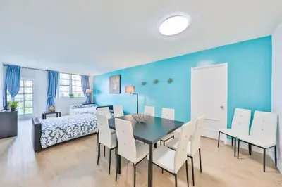 a dining room with a table and chairs and a bed at Coastal Elegance Oasis in Sunny Isles STR-01308 in Sunny Isles Beach