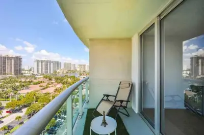 a balcony with a chair and a view of the city at Condo with Stunning View STR-01307 in Sunny Isles Beach