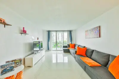 a living room with a couch and a tv at Family getaway steps from the ocean STR-01305 in Sunny Isles Beach