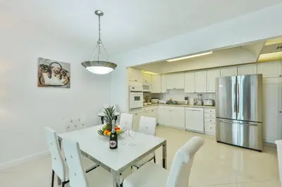 a kitchen with a table and chairs and a refrigerator at Family getaway steps from the ocean STR-01305 in Sunny Isles Beach