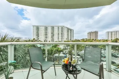 a balcony with chairs and a table and a view of a city at Family getaway steps from the ocean STR-01305 in Sunny Isles Beach