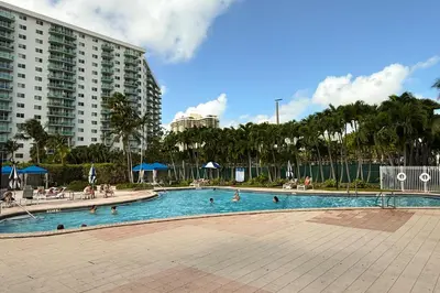 a swimming pool in a resort with people in it at Family getaway steps from the ocean STR-01305 in Sunny Isles Beach
