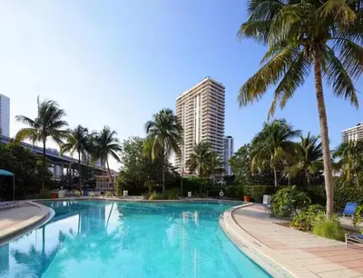 a swimming pool with palm trees and a tall building at Condo on the Beach-STR 01309 in Sunny Isles Beach