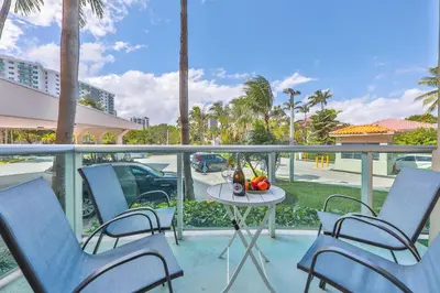a balcony with chairs and a table with fruit on it at Ocean reserve 1st floor across the beach STR-02382 in Sunny Isles Beach