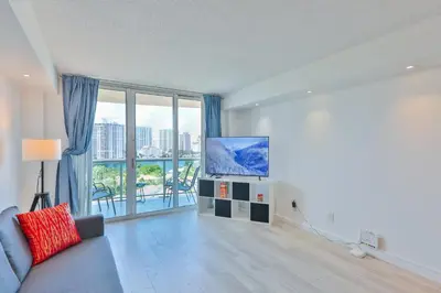 a living room with a couch and a flat screen tv at Ocean Vista in Sunny Isles Beach