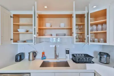 a kitchen with white cabinets and a sink at Ocean Vista in Sunny Isles Beach