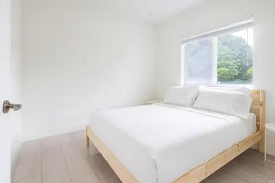 a white bed in a white room with a window at 3BR Getaway, 4 Beds, Near Beach, Free Parking in Hallandale Beach
