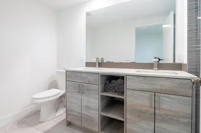 a bathroom with a sink and a toilet and a mirror at 3BR Getaway, 4 Beds, Near Beach, Free Parking in Hallandale Beach