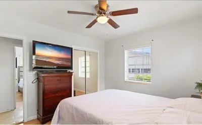 a bedroom with a ceiling fan and a flat screen tv at Private King Master Suite Near Hardrock Stadium in Miami Gardens
