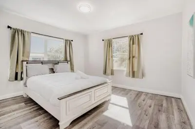 a white bedroom with a bed and two windows at Lauderdale Breeze Villas - Coastal 2 Bedroom in Fort Lauderdale