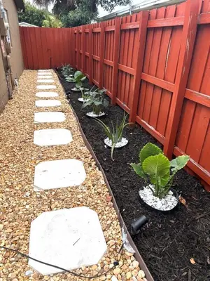 a garden with a fence and a row of plants at Exclusive suites in Fort Lauderdale