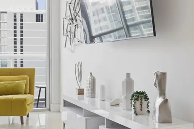 a living room with a yellow chair and a white table at Luxury Brickell Condo with Skyline & Bay Views in Miami