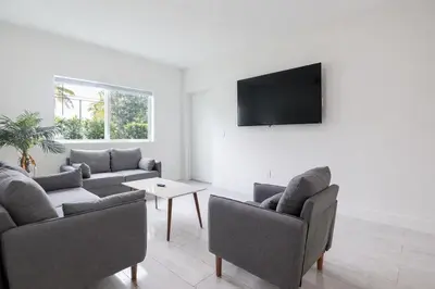 a living room with two couches and a flat screen tv at Modern 3BR Getaway 4 Beds with Free Parking Included in Hallandale Beach
