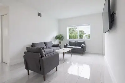 a living room with two couches and a table at Modern 3BR Getaway 4 Beds with Free Parking Included in Hallandale Beach