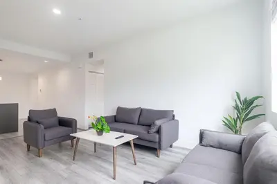 a living room with two couches and a table at Stylish 3BR Apartment, 4 Beds, Great for Groups with Free Parking in Hallandale Beach