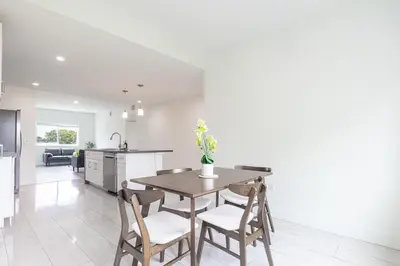 a kitchen and dining room with a table and chairs at Stylish 3BR Apartment, 4 Beds, Great for Groups with Free Parking in Hallandale Beach