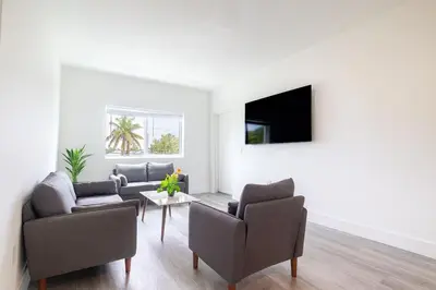a living room with a couch and chairs and a table at Stylish 3BR Apartment, 4 Beds, Great for Groups with Free Parking in Hallandale Beach