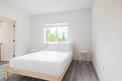 a white bedroom with a bed and a window at Stylish 3BR Apartment, 4 Beds, Great for Groups with Free Parking in Hallandale Beach
