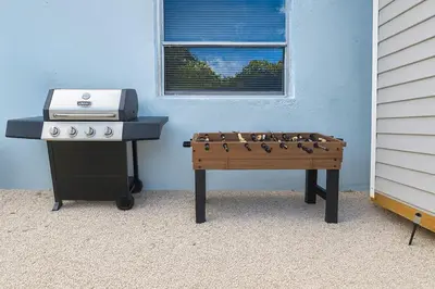 a ping pong game on a table next to a stove at Comfy 2BR Apartment Near Las Olas with Patio, BBQ and FREE PARKING in Fort Lauderdale