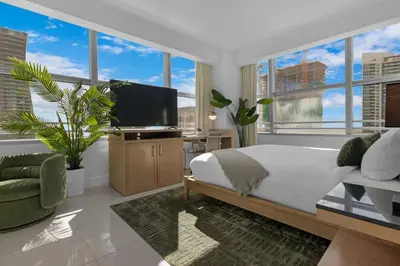 a bedroom with a bed and a tv and some windows at Luxury Brickell 3BD Free Parking - Pool - Bay View in Miami