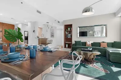 a living room with a table and a green couch at Luxury Brickell 3BD Free Parking - Pool - Bay View in Miami
