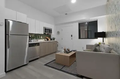 a kitchen and living room with a couch and a refrigerator at Voy House Wynwood with Rooftop Pool in Miami