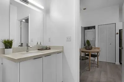 a white bathroom with a sink and a table at Voy House Wynwood with Rooftop Pool in Miami