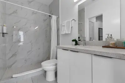 a white bathroom with a toilet and a shower at Voy House Wynwood with Rooftop Pool in Miami