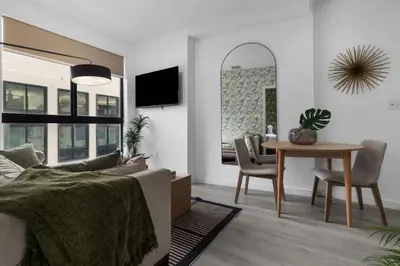 a bedroom with a bed and a table and a dining room at Voy House Wynwood with Rooftop Pool in Miami