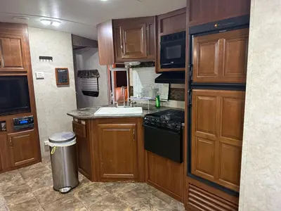 a small kitchen with wooden cabinets and a stove at Getsemany Inc RV Dreams Hollywood in Hollywood
