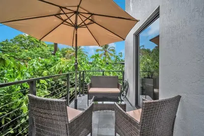 a balcony with a chair and an umbrella at Sandra's Place - Family - Entire 8BR-6BA in Miami