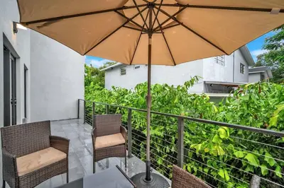 a patio with a table with an umbrella and chairs at Sandra's Place - Family - Entire 8BR-6BA in Miami
