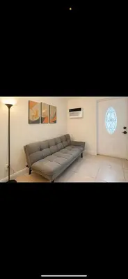 a living room with a couch and a window at Santorini Wynwood in Miami