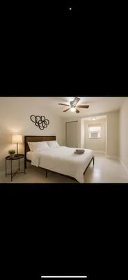 a white bedroom with a bed and a ceiling fan at Santorini Wynwood in Miami