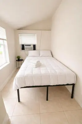 a bed with a white mattress in a room at Santorini Wynwood in Miami