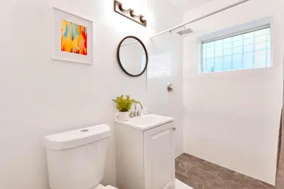 a white bathroom with a toilet and a mirror at Relaxing Studio with Modern Comfort in Miami