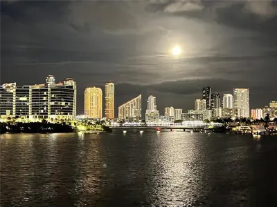 a view of a city at night with the moon at Serene Waterfront Condo - Bayview, pool & tennis in Aventura