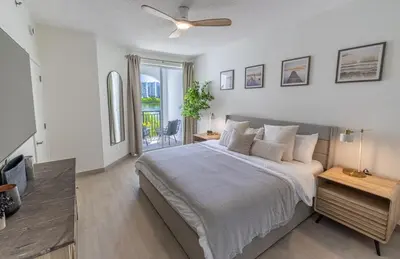 a bedroom with a large bed with a ceiling fan at Serene Waterfront Condo - Bayview, pool & tennis in Aventura
